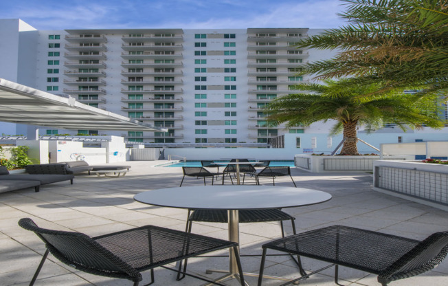 A table and two chairs on an outdoor patio outside apartments for rent near Miami Beach.