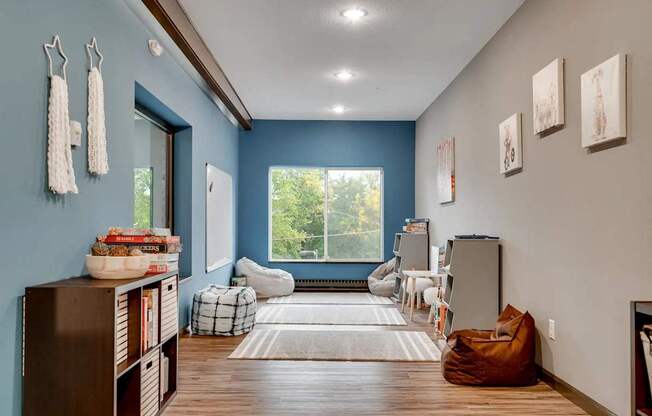 a living room with blue walls and a large window. Circle Pines, MN Lexington Lofts