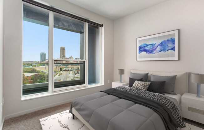 a bedroom with a bed and a large window with a city view