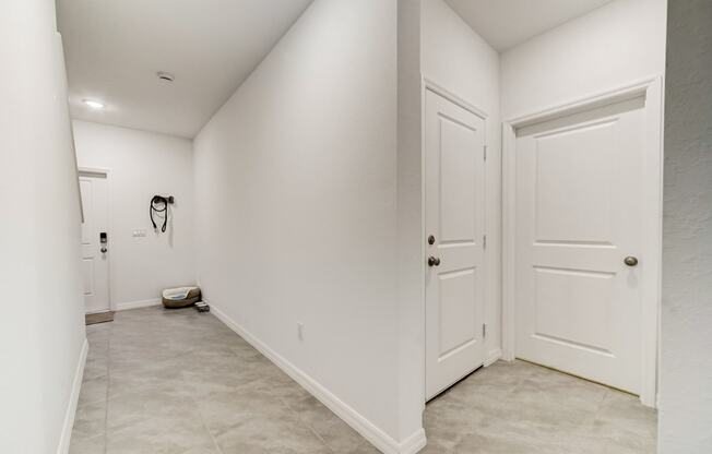 Boatman Hammock Townhomes in Lake Worth, FL photo of  a white hallway with two doors and a toilet in the corner