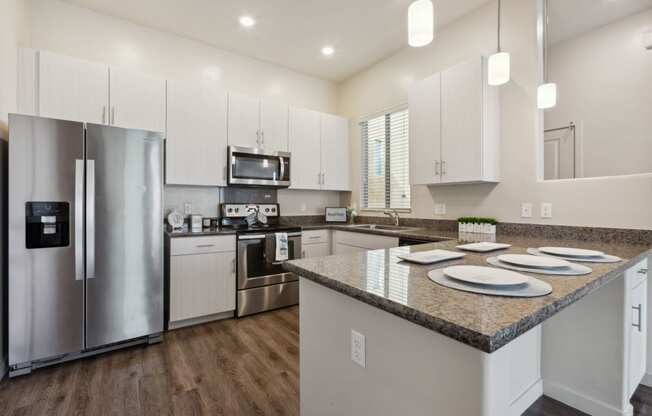 a kitchen with white cabinets and stainless steel appliances