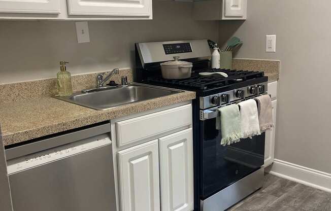 A kitchen with white cabinets and a black countertop.