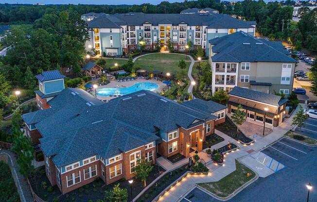 an aerial view of the resort at night with a swimming pool