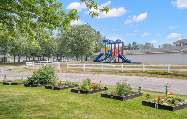 a playground in the background with a bunch of flowers in the foreground