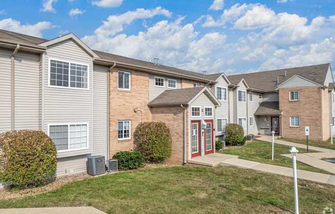 a row of townhomes with grass and a sidewalk in front of them