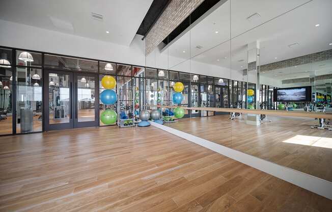a large gym with a wooden floor and large mirrors on the wall at Altis Grand Central, Tampa, 33606