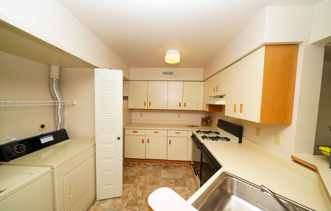 Kitchen with Washer Dryer Set at Dupont Lakes Apartments, Fort Wayne, Indiana