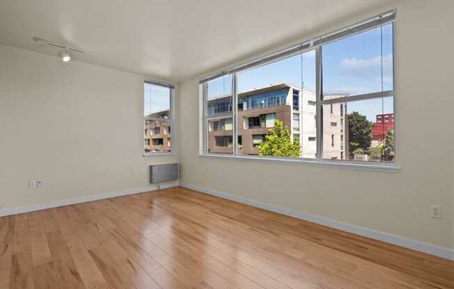 a living room with a large window and wooden floors