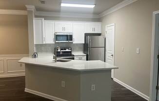 a kitchen with white cabinets and a white counter top at The Berkeley Apartments, Georgia, 30096