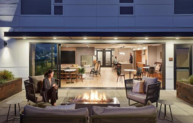 a woman sitting on a couch in front of a fire pit