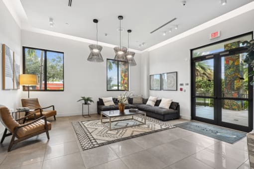 Lobby area with L sectional couch and designer lights at Bay Village 1 in Palmetto Bay, FL