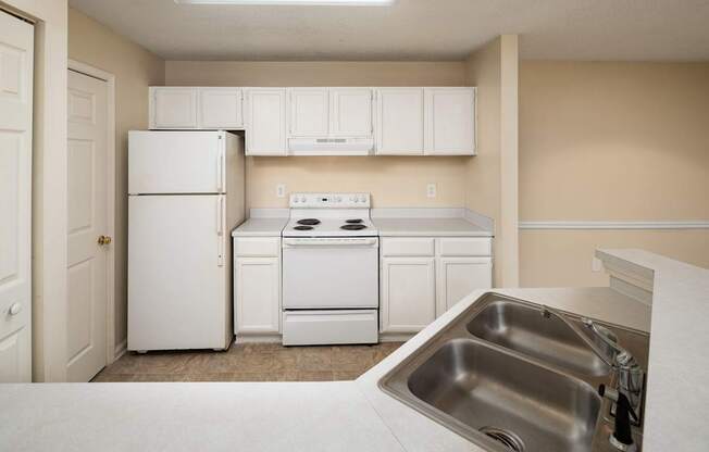 Classic style kitchen with white appliances and cabinets.