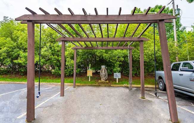 A wooden structure over car care center is situated in a parking lot.