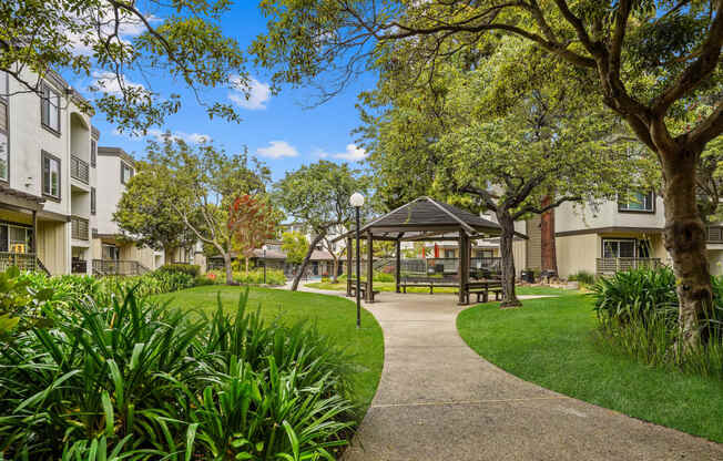 a park with a gazebo and trees in front of apartment buildings