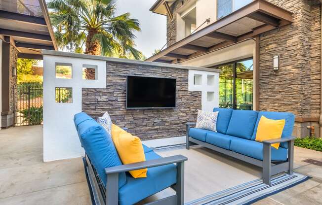 a living room with blue couches and a television at Metro Gateway, Riverside