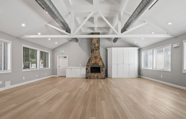 a large living room with a fireplace and wooden floors
