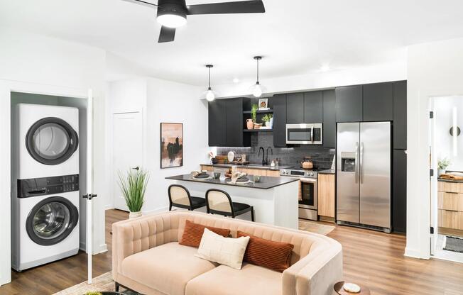 An open living area at Modera Nations in Nashville features wide-plank flooring, an island kitchen, and in-home laundry for seamless everyday living.