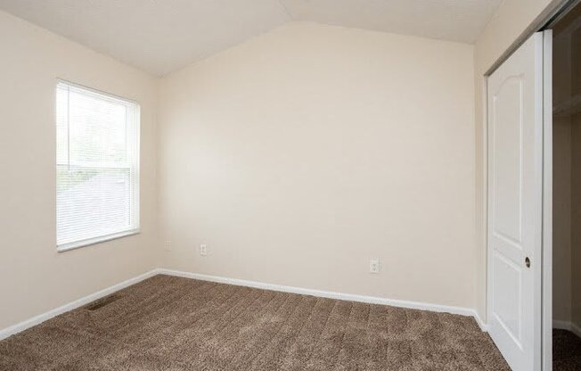 an empty room with a door and a window