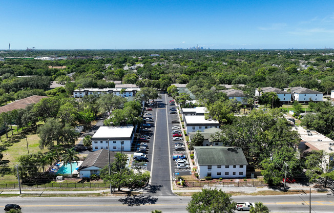 Aerial view of a charming residential area with lush greenery, well-maintained roads, and a sparkling pool inviting relaxation.
