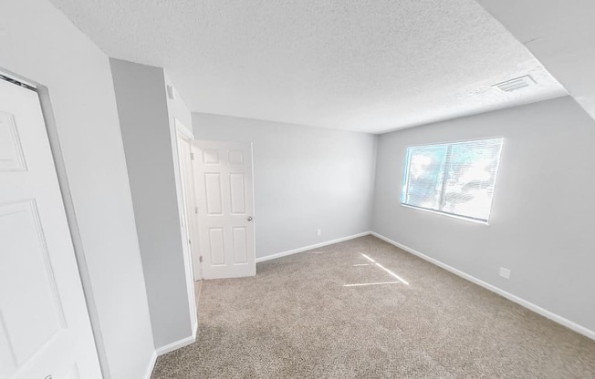 an empty room with carpet and a window