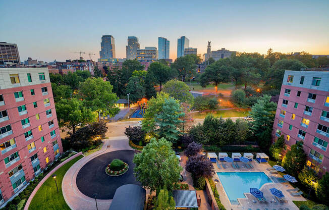 an aerial view of a swimming pool and a city at dusk