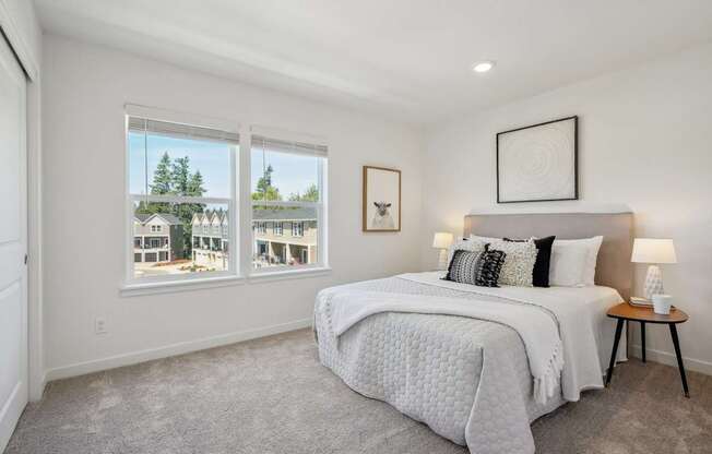 a bedroom with a bed and two windows