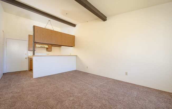 a kitchen and dining area in a room with white walls and carpet at Park Columbia Apts, Hemet, CA 92544