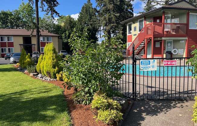 a house with a pool and a fence in front of it