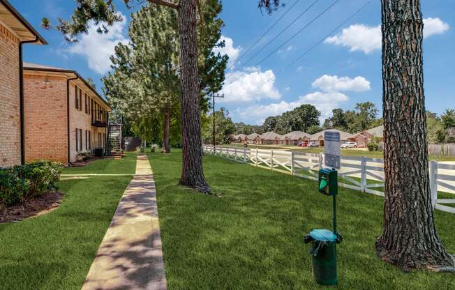 a sidewalk in front of a white fence and a fire hydrant