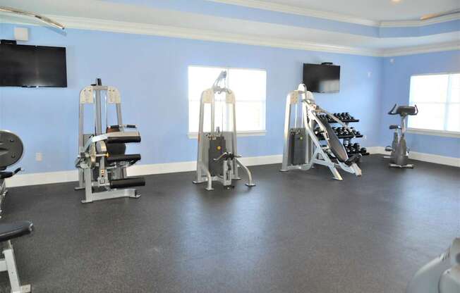 A gym with a variety of equipment including treadmills, stationary bikes, and weight machines.