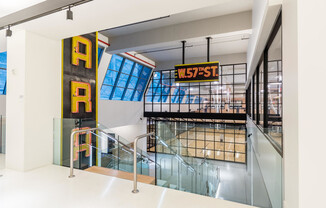 The Max 606 W 57th St Social Staircase with vintage neon details and skylights overlooking the gym a