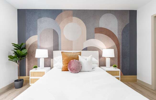 a bedroom with a white bed and a wall with circles on it