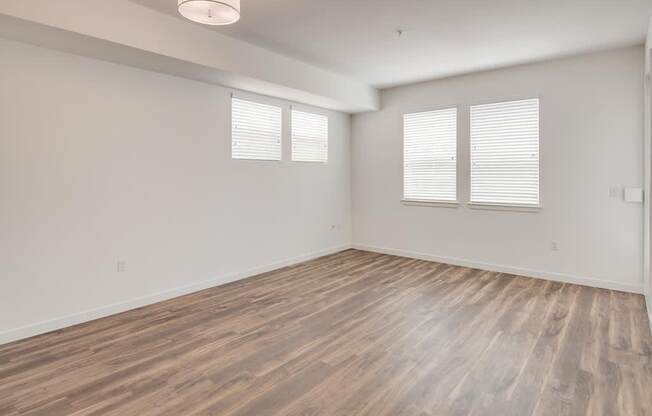 an empty room with white walls and a wooden floor