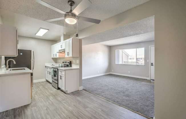 A kitchen with a fan and a dining table.