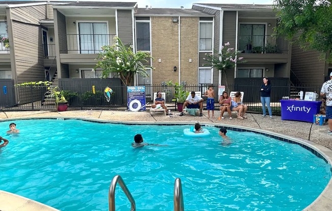 A group of people are gathered around a pool.