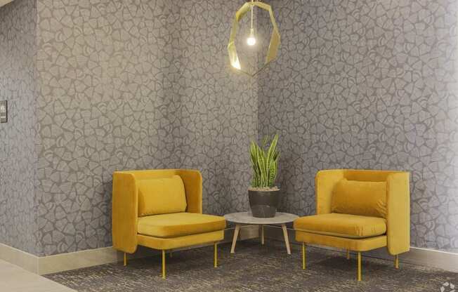 Two yellow chairs are placed in front of a grey patterned wall.