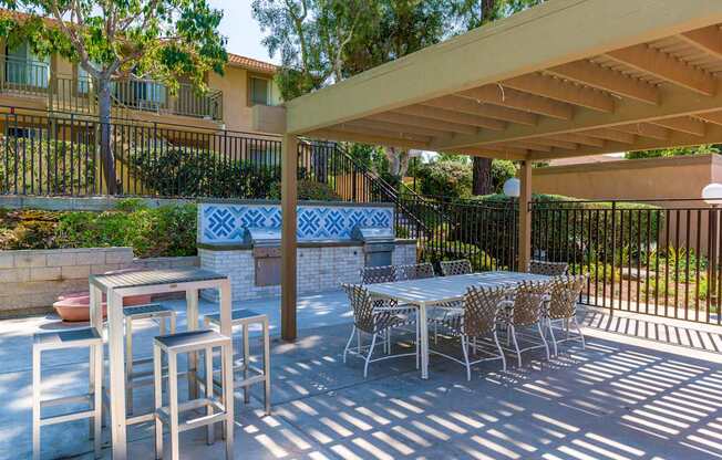A patio with a table and chairs under a roof.