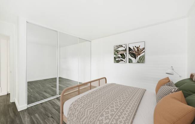 A bedroom with a bed, a chair, and a painting on the wall.