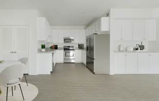 A modern kitchen with white cabinets and stainless steel appliances.