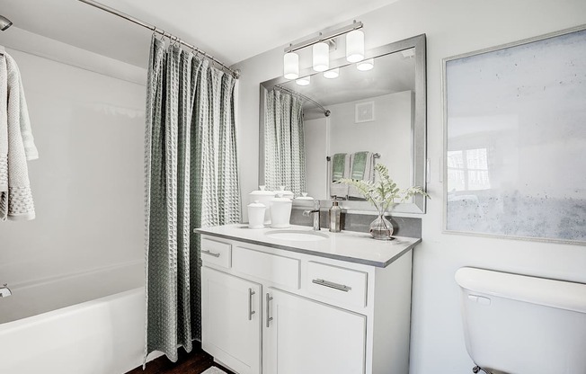 A white bathroom with a white tub, sink, and towel.