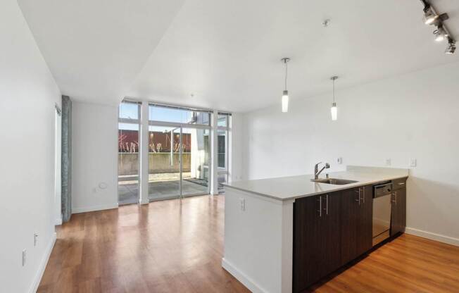 A kitchen with white walls and wooden floors.