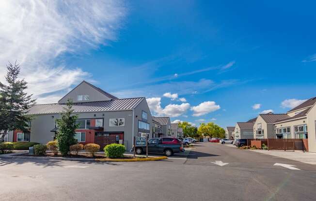 a parking lot in front of houses with a blue sky