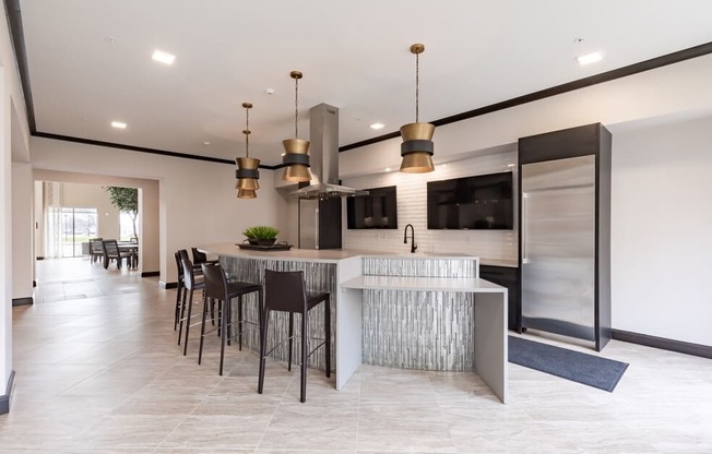 a kitchen with a large center island with a breakfast bar