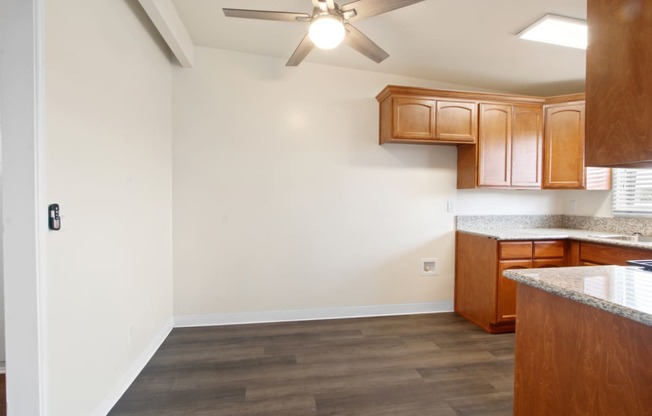 a kitchen with wood cabinets and a ceiling fan