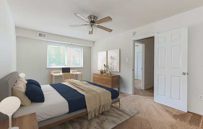 a bedroom with a bed and a ceiling fan and a door to a bathroom at halley house apartments in washington dc