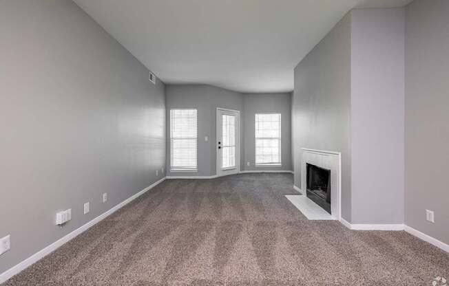 A room with a fireplace and carpeted floor.