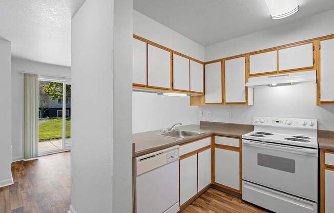 a kitchen with white appliances and wooden cabinets