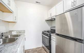 A kitchen with a stainless steel refrigerator, oven, and microwave.