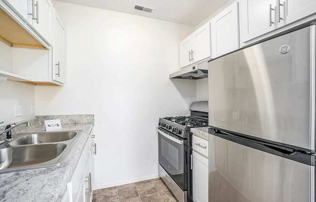 A kitchen with a stainless steel refrigerator, oven, and microwave.
