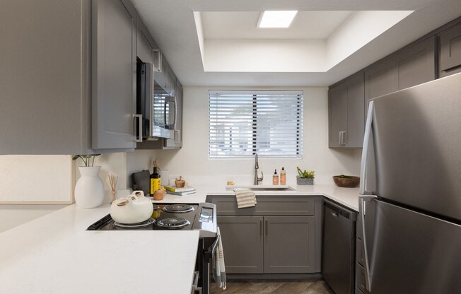 a kitchen with gray cabinets and a white counter top